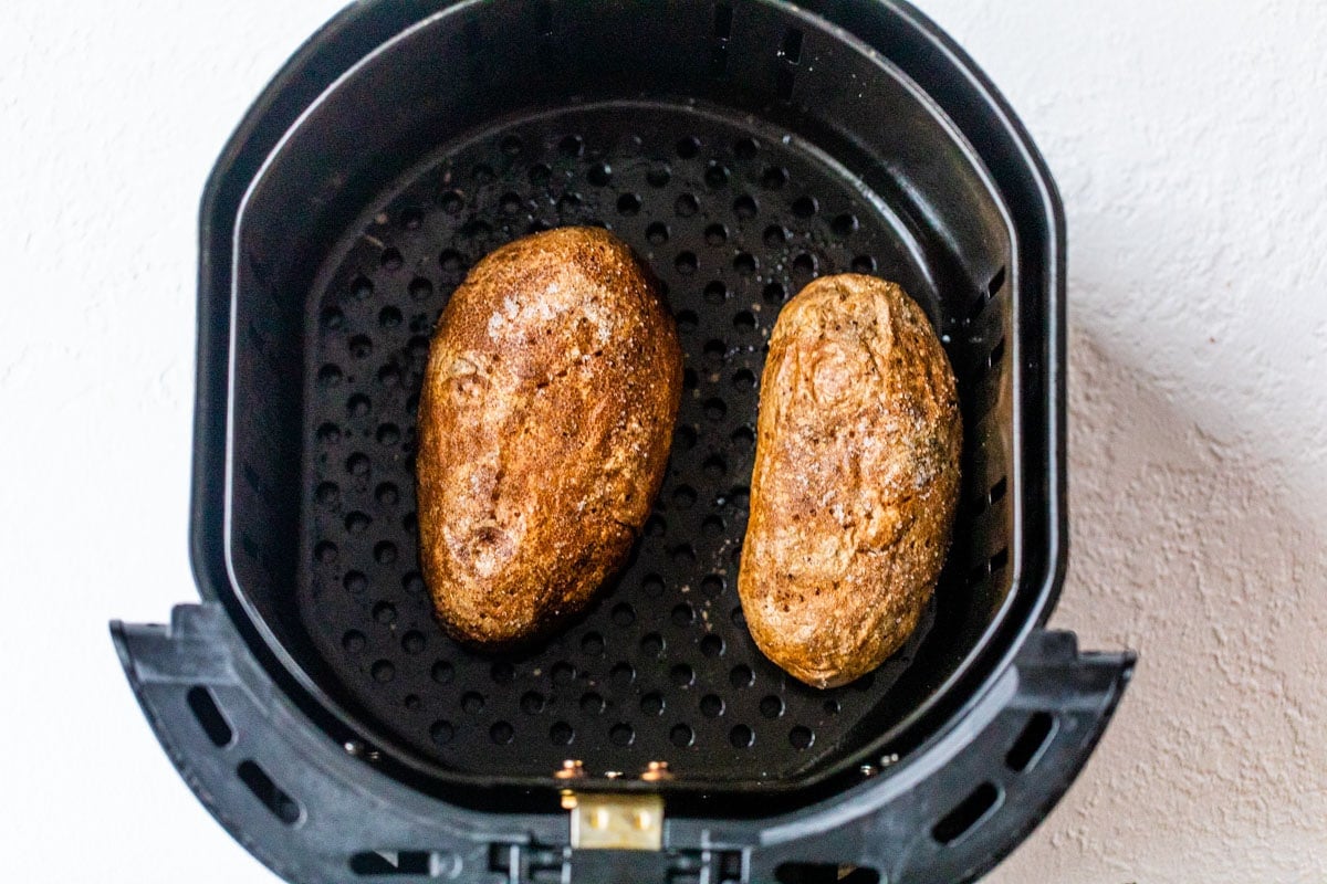 Two potatoes in an air fryer